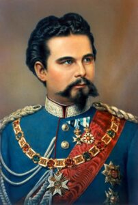 The image shows King Ludwig II of Bavaria. He is dressed in a very colorful military uniform with many decorations and awards. 